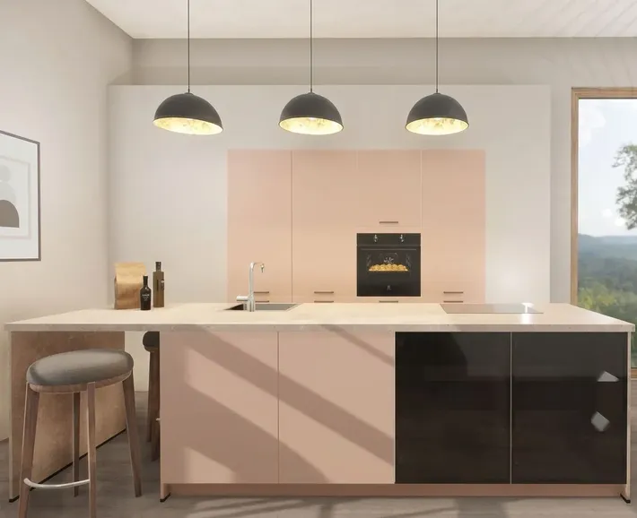 Moderni keittiö mit Hydra-ovet im sanften korallinton. Die warmen, mattaen keittiönschränke im Hintergrund und die Insel im Vordergrund setzen einen farbigen Akzent, abgerundet durch schwarze Design-Elemente und drei schwarze riippuvalaisimet.